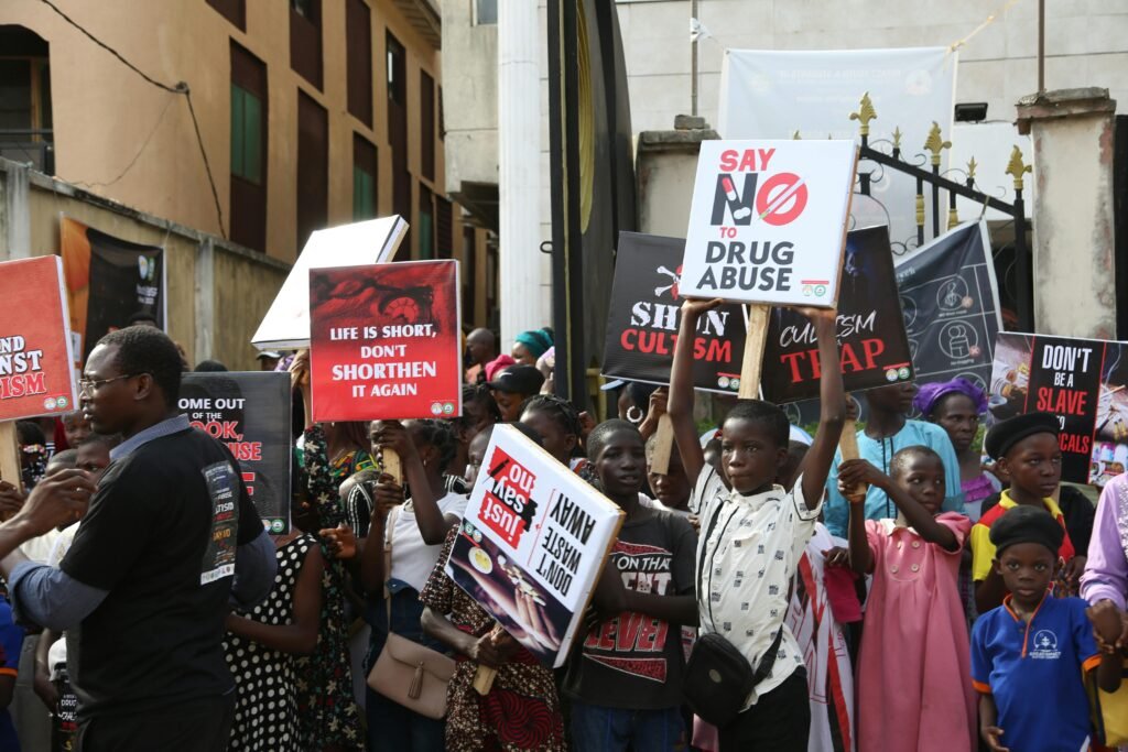 Group of people protesting against drug abuse, holding placards with slogans.